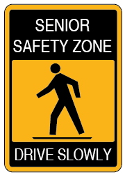 Yellow and Black sign with a man walking that reads senior safety zone, drive slowly.