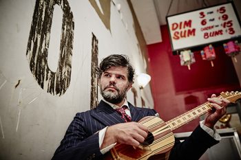 Photograph of Kobotown sitting with a guitar