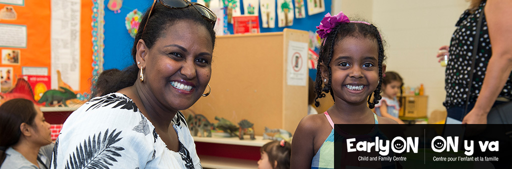 A caregiver and child smiling.