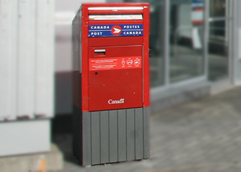 Canada Post mailbox on a city street on a sunny day