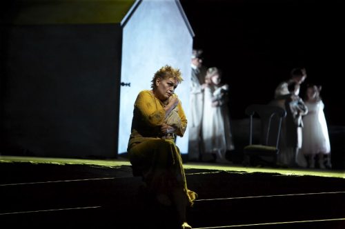 Lone female performer on front stage - ensemble cast in background. Photo credit: Susan Bullock as Elektra (foreground) in the Canadian Opera Company’s production of Elektra, 2007, photo; Michael Cooper.
