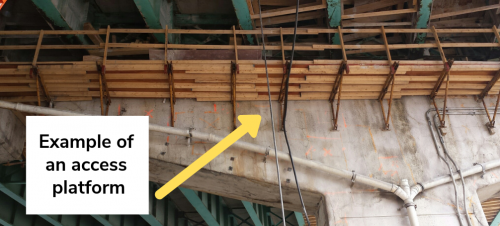 Image of the underside of the Gardiner Expressway West Deck that shows an example of an installed access platform. The access platform depicted is a wooden structure that is installed on the underside of the Expressway along the bent.