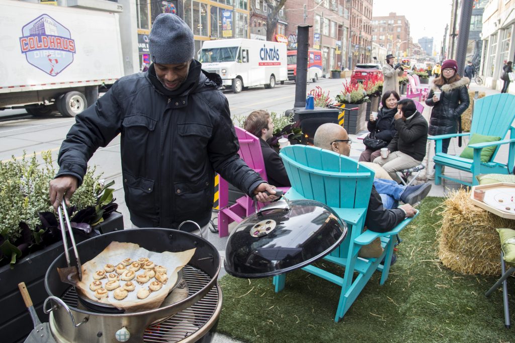 Man cooking on a grill in the curbspace on King Street