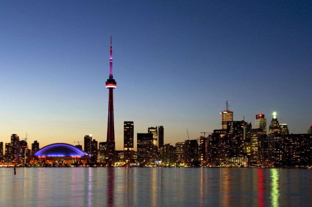 Toronto skyline from water. CN Tower. Lights reflected in Lake Ontario.,