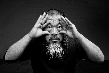 Ai Weiwei staring into camera - black and white. Hands at eyes.