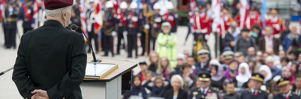 image of a D-Day veteran telling his story to the crowd that is gathered for the D-day ceremony on Nathan Phillips Square