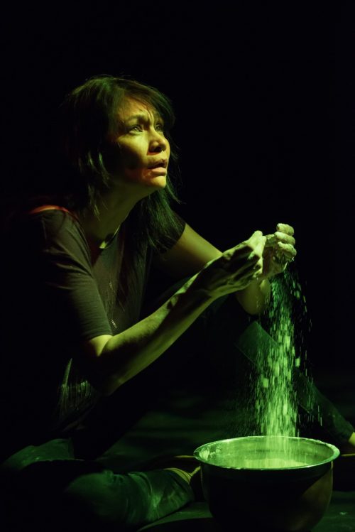 Photo info: Michelle Thrush in Inner Elder. Photo credit: Ben Laird. Woman with powder falling from hands into bowl
