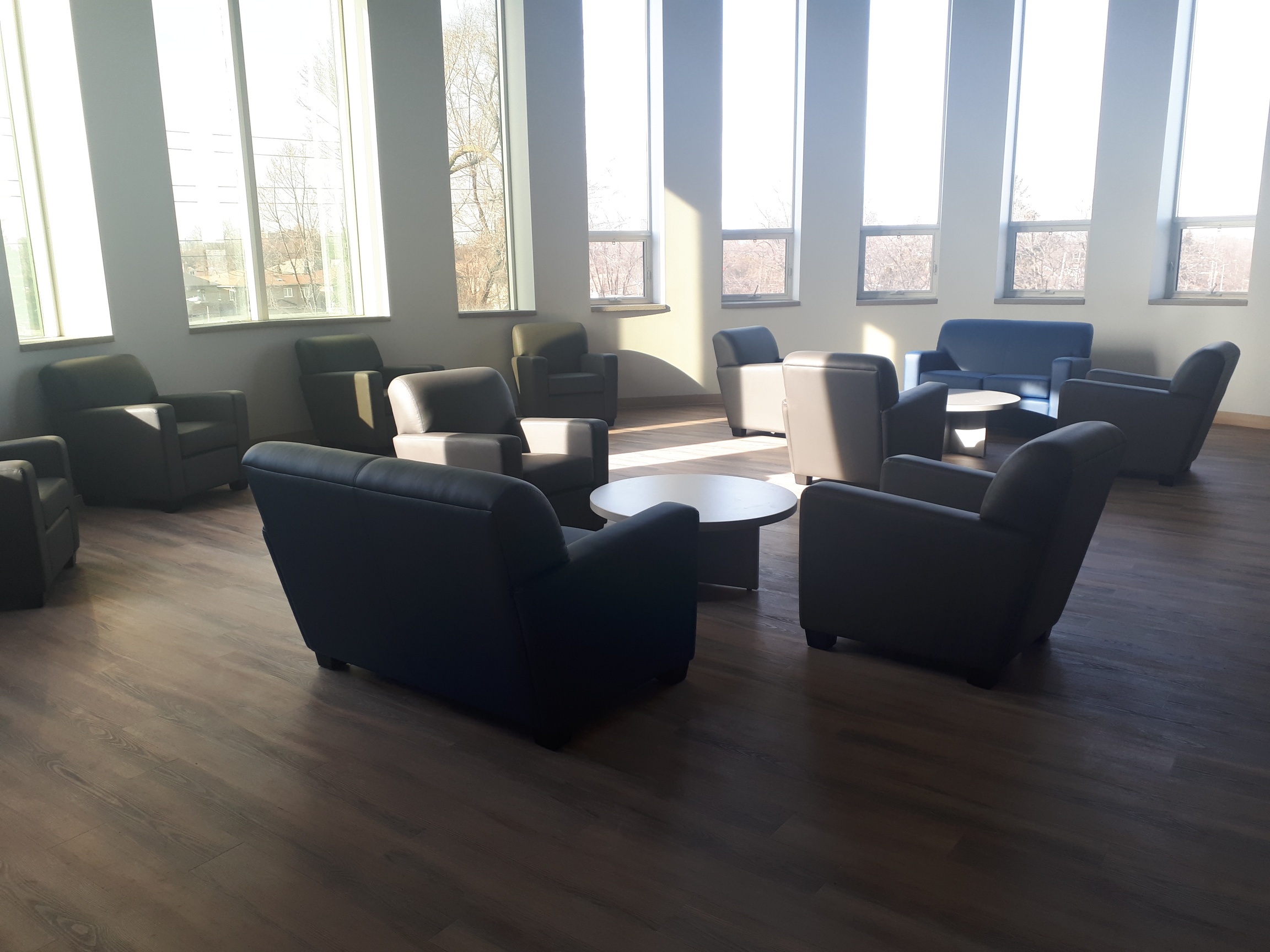 open lounge area with couches and multiple windows surrounding the lounge