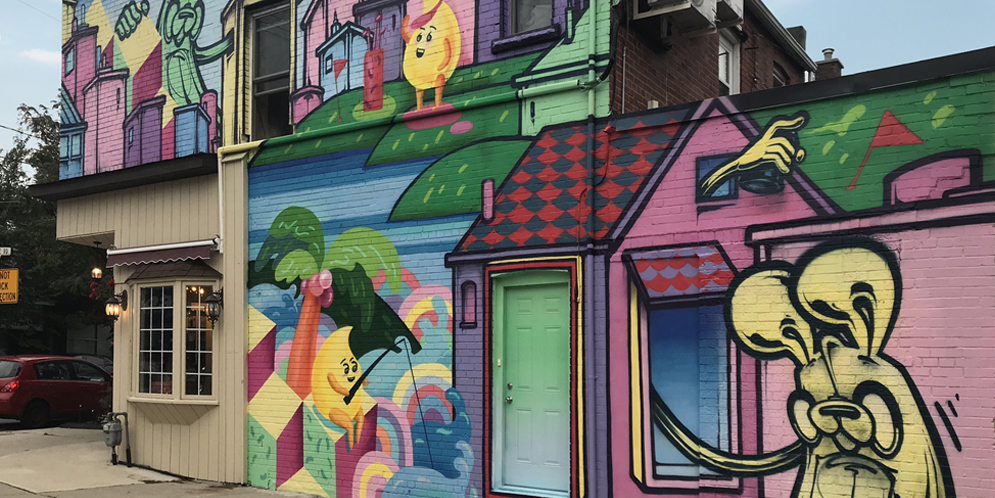 colourful mural on side of commercial building of fantasy city with raindrop creatures