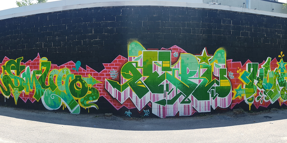 colourful green mural of random block letters, graffiti style