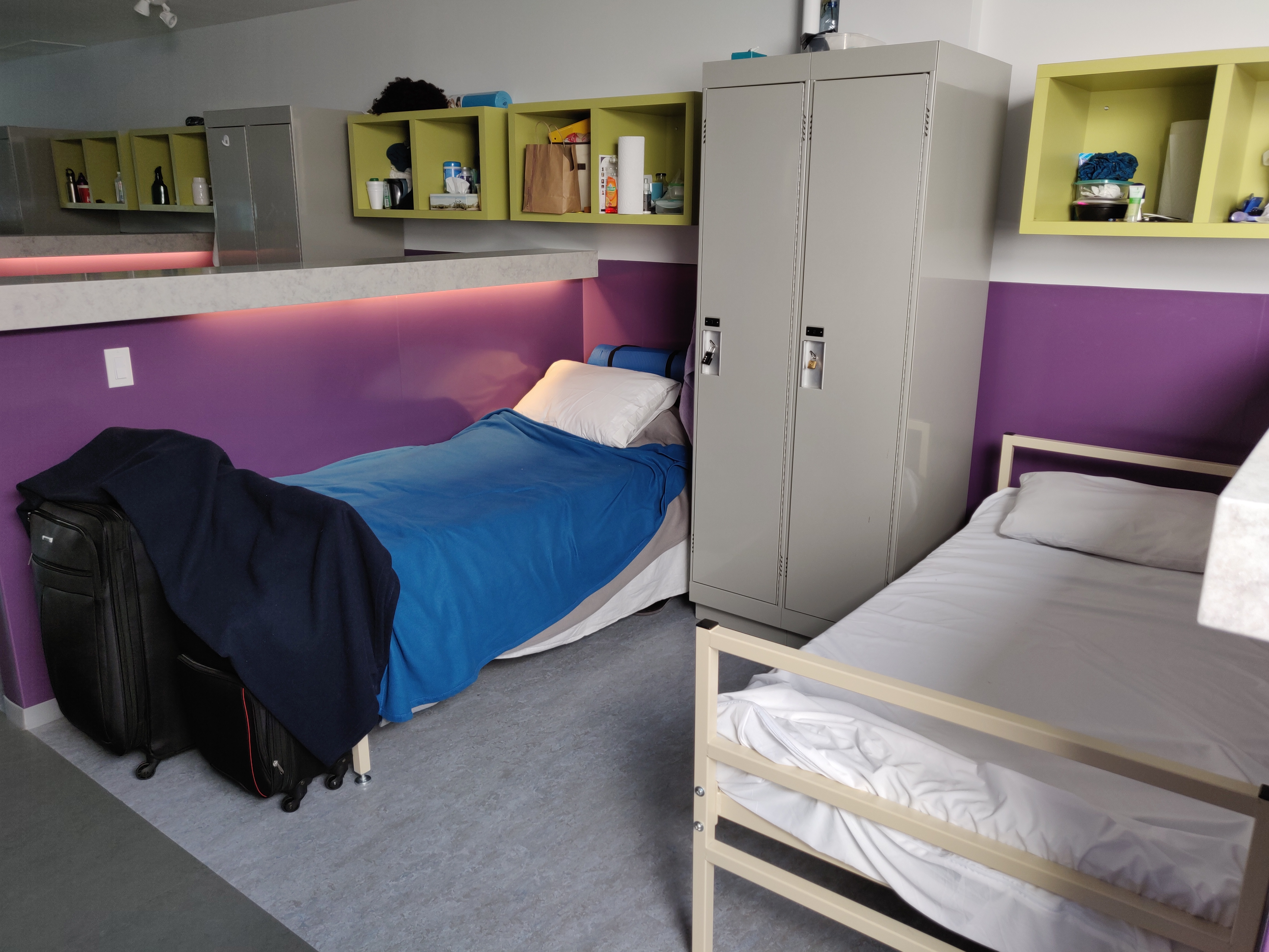 two beds sharing a semi private area with half-wall dividers and individual lockers for personal items