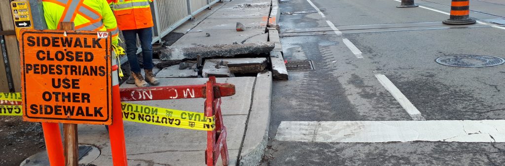 two construction workers doing utility cuts to a curb