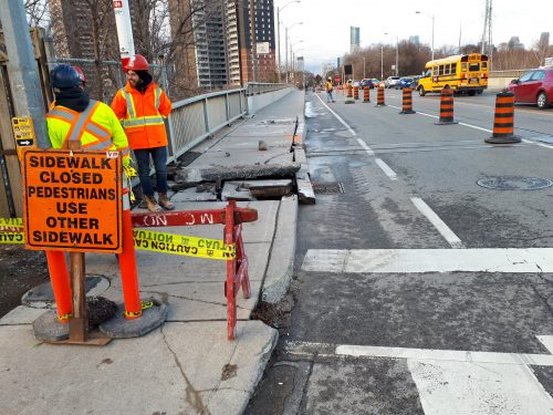 two construction workers doing utility cuts to a curb