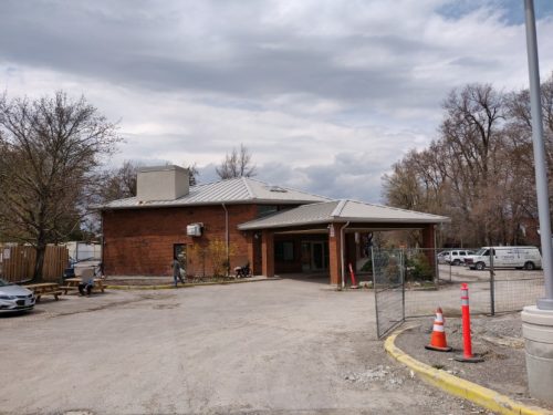 Exterior of the Scarborough Village Residence with benches and residents sitting outside