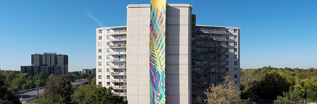 Colorful mural banner painted on side of a tall building