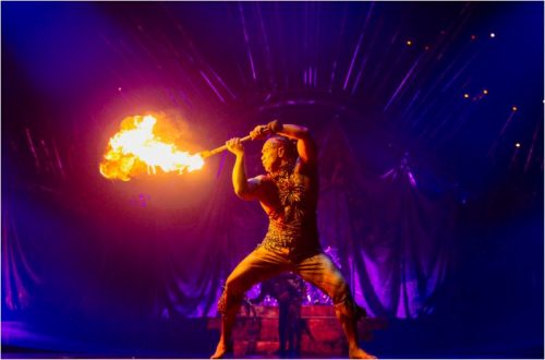 Image info: Crédit : Marie-Andrée Lemire / Costumes Dominique Lemieux / Cirque du Soleil 2019. Performer spinning fire on stage