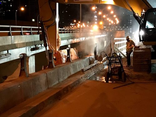 Image of westbound Gardiner Yonge-Bay-York off-ramp work zone, crews remove concrete parapet wall at the top of the ramp.