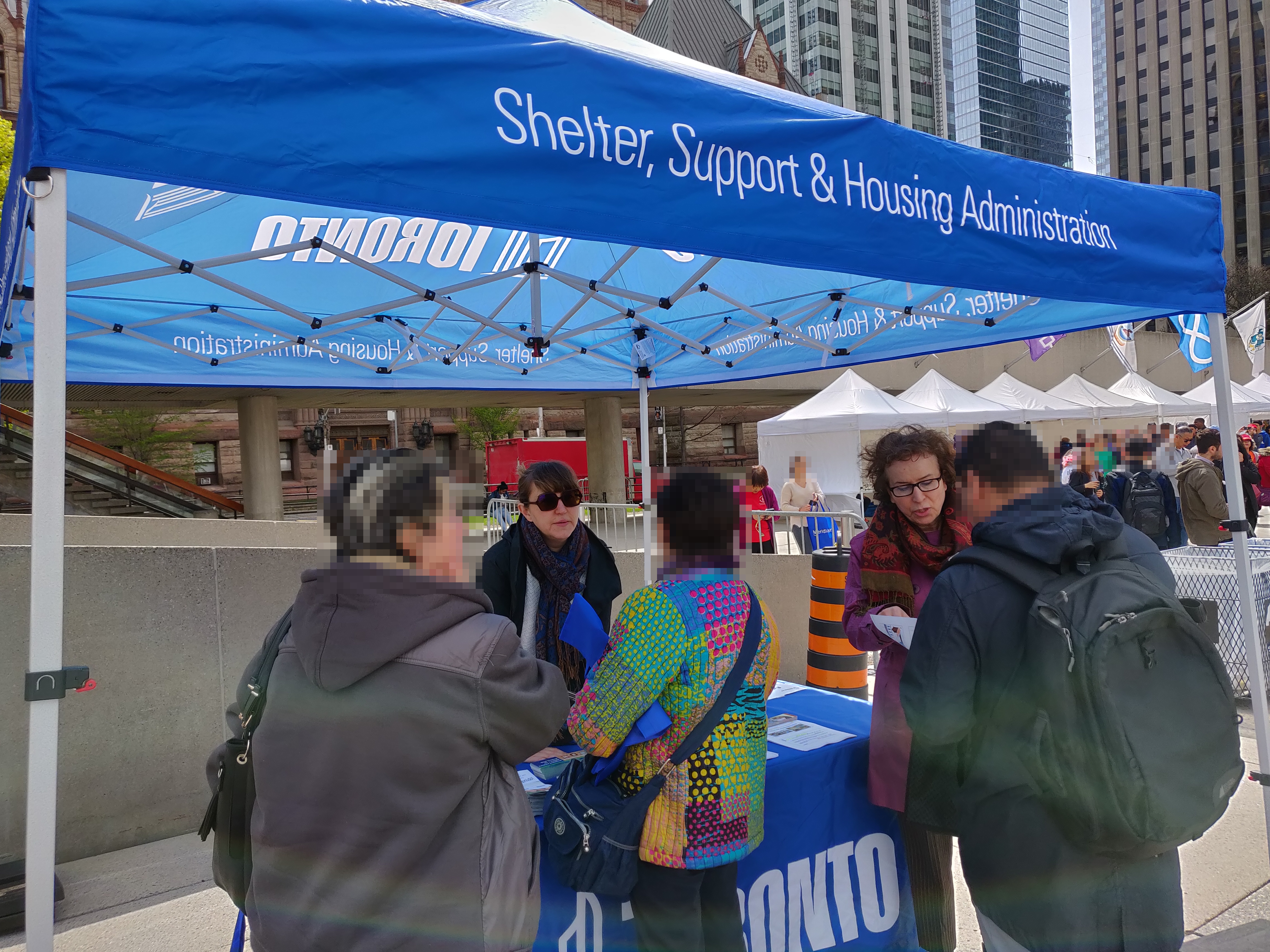 two SSHA staff members talking to community members at a local street event