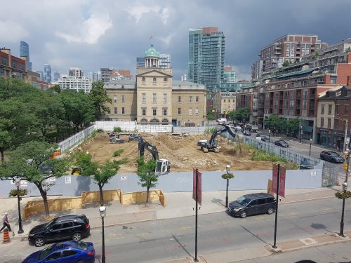 Construction progress at North St. Lawrence Market showing cranes and dirt enclosure.