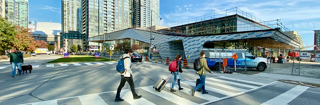 People cross the street near the developing community centre