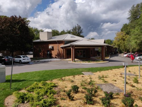 Exterior of the Scarborough Village Residence with benches and residents sitting outside