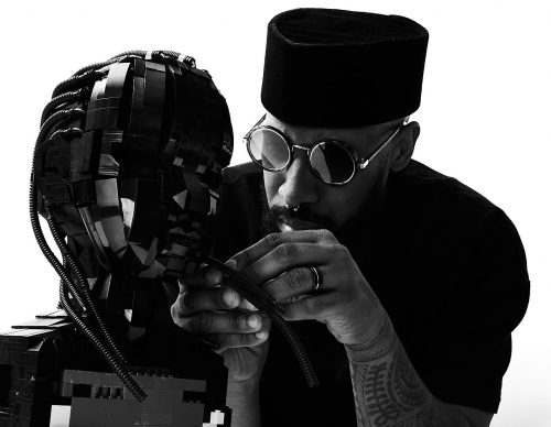 Image info: Ekow Nimako, Building Black: Civilizations. Photo is courtesy of the artist. close up of artist working on piece