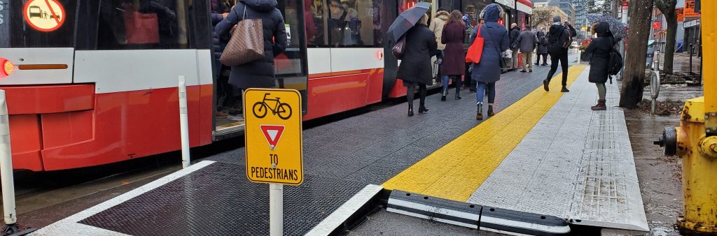 Streetcar stopped at raised platform with people entering streetcar