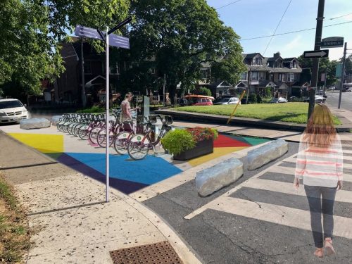 Artist rendering of the proposed features at the closed segment of St. Helens Avenue, including road mural, bike share station, planter boxes, wayfinding signs and armour stone.