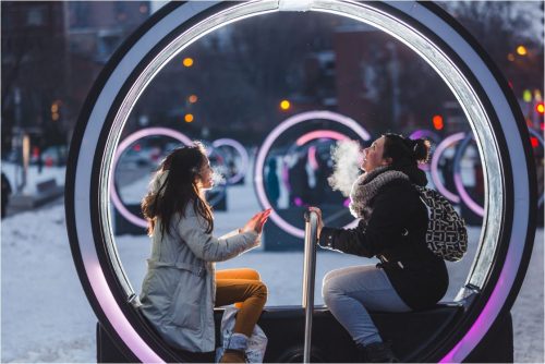 Image info: Loop. Photo Ulysse Lemerise. OSA Images. two people in large lighted circle with handle for moving it.