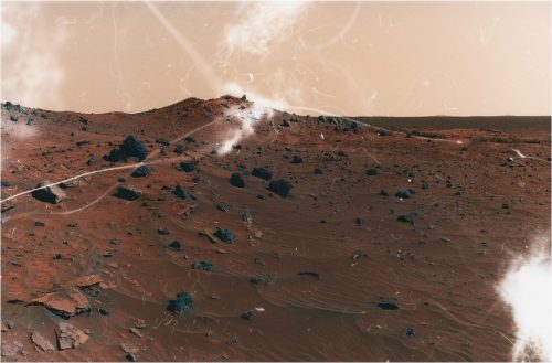 Barren Mars-like landscape with rocks and reddish sand.