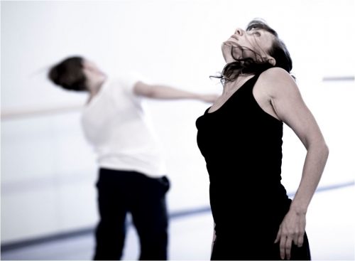 2 dancers - foreground in black with head tipped back; background in white, head tipped to side