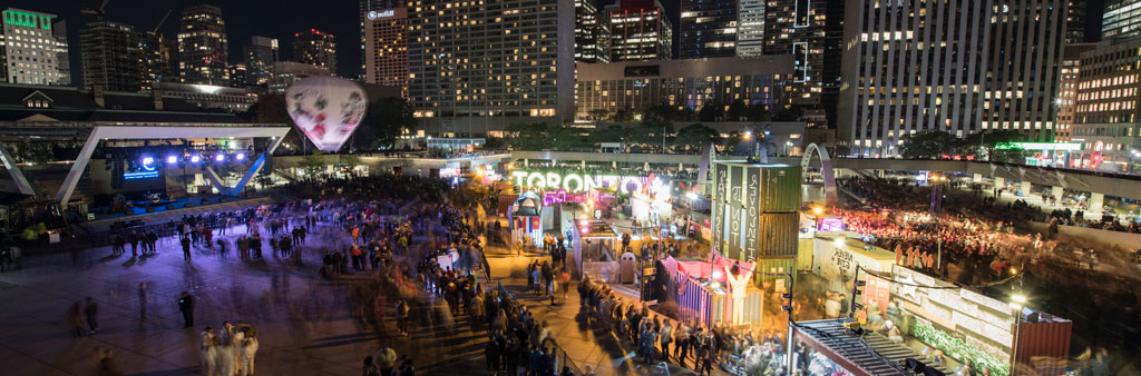 Fair and market at Nathan Phillips Square at night with Toronto Sign in the background.