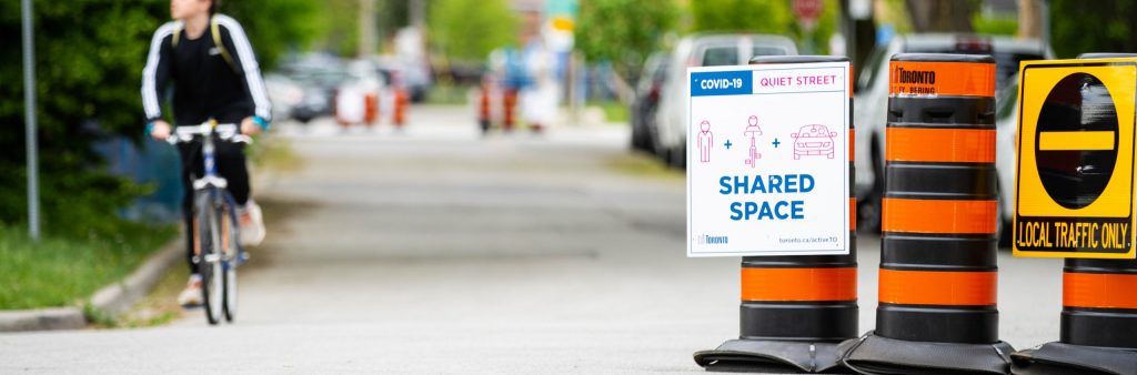 Image of a street with barrels blocking some of the street to encourage people to slow down