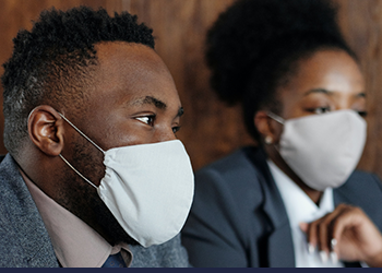 Man and woman wearing masks indoors