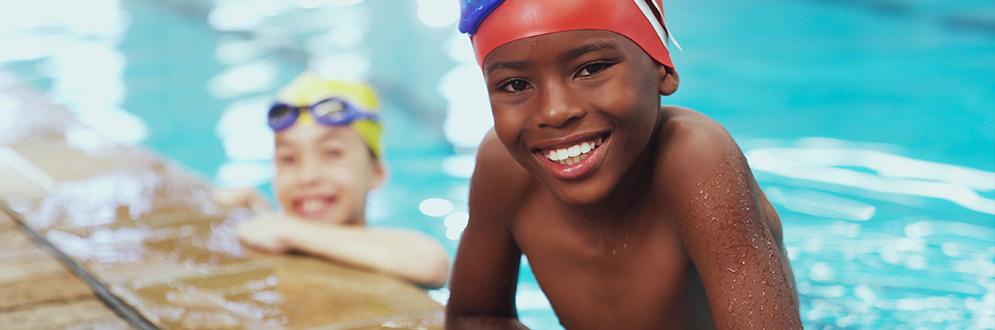 two young boys smiling in a pool