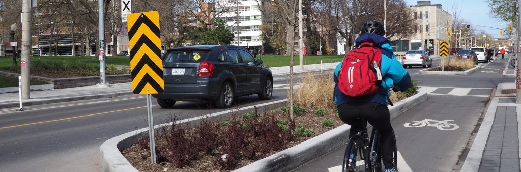 Cyclists in a protected cycle track on Gerrard Street West