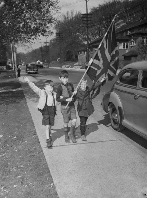 Photograph of 3 children with Union Jack, celebrating VE Day.