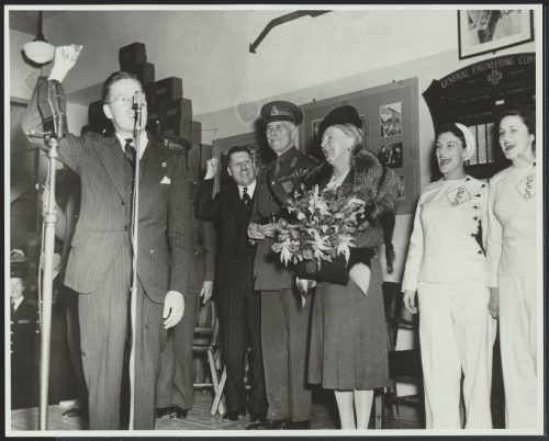 Visitor making speech to workers in factory