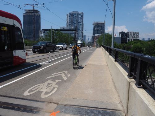 Image of Dundas Street after the bike lane installation with painted bike lanes separated by bollards