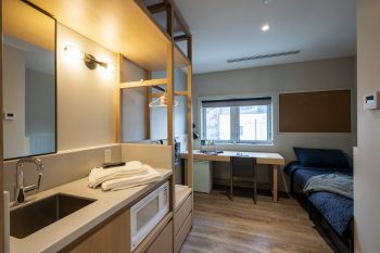 kitchenette in bedroom, includes a sink and microwave.