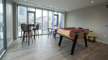 table soccer and a high table with four chairs in front of window.