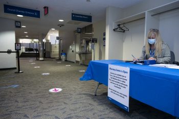 blue table with City staff member who welcomes those who need the warming cenre