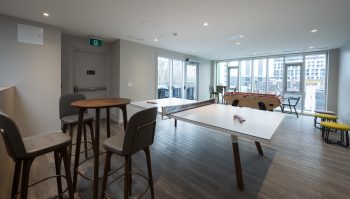 ping pong table and high chairs in lounge with windows