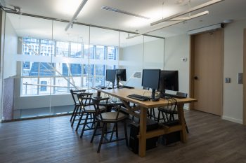 Four computers and chairs in front of window