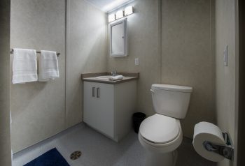 Washroom in an 11 Macey Ave unit. Toilet, sink, towel and mirror. 