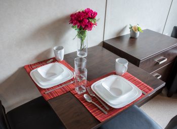 Dining table with cutlery and dishware on dining table. 