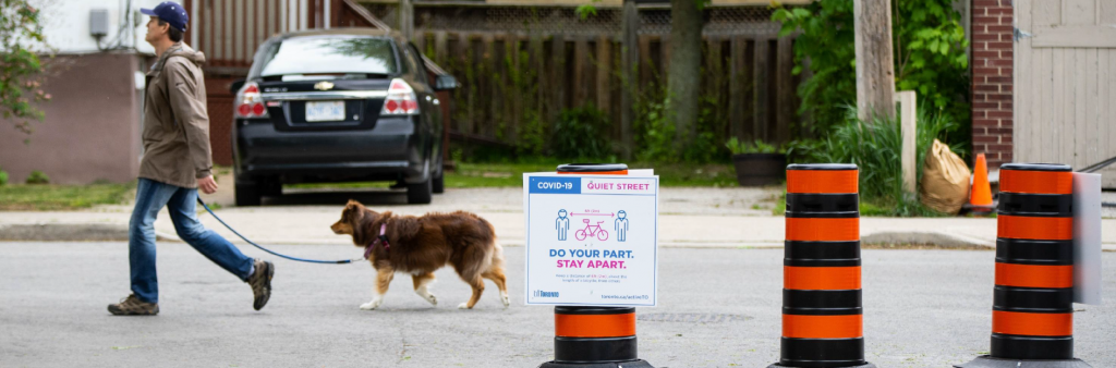 A person walking their dog on a Quiet Street.