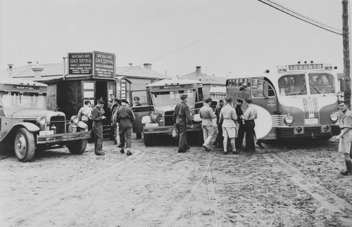 Uniformed men boarding buses.