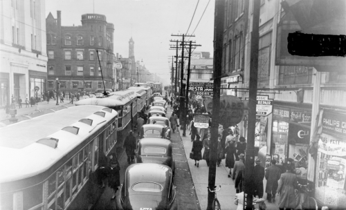 A bumper-to-bumper line of streetcars and motor cars on a city street.