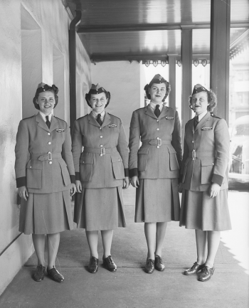 Four women in uniform with hats.